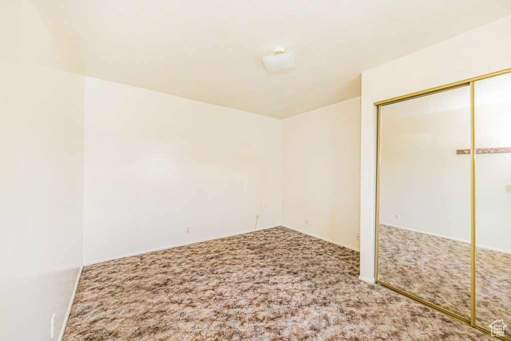 Unfurnished bedroom featuring a closet, carpet, and baseboards