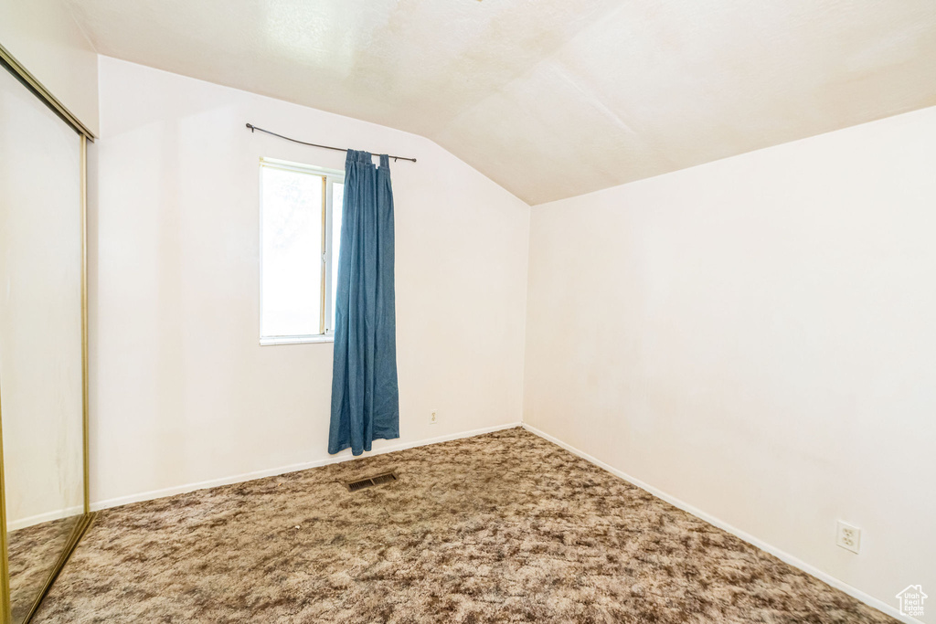 Interior space with visible vents, baseboards, and lofted ceiling