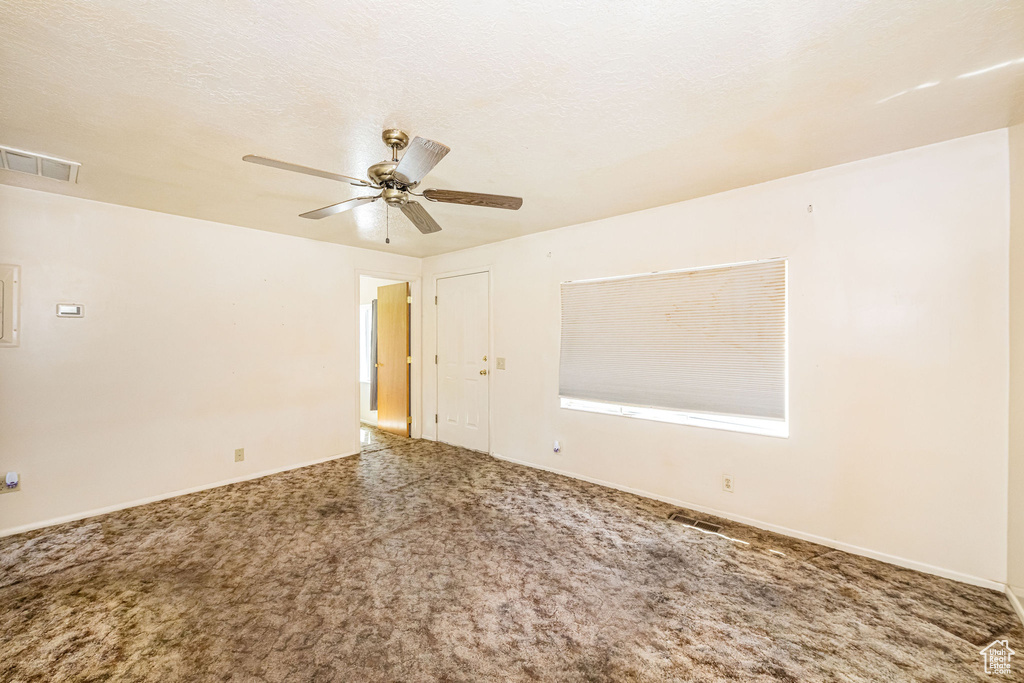 Carpeted spare room featuring a ceiling fan, baseboards, and visible vents