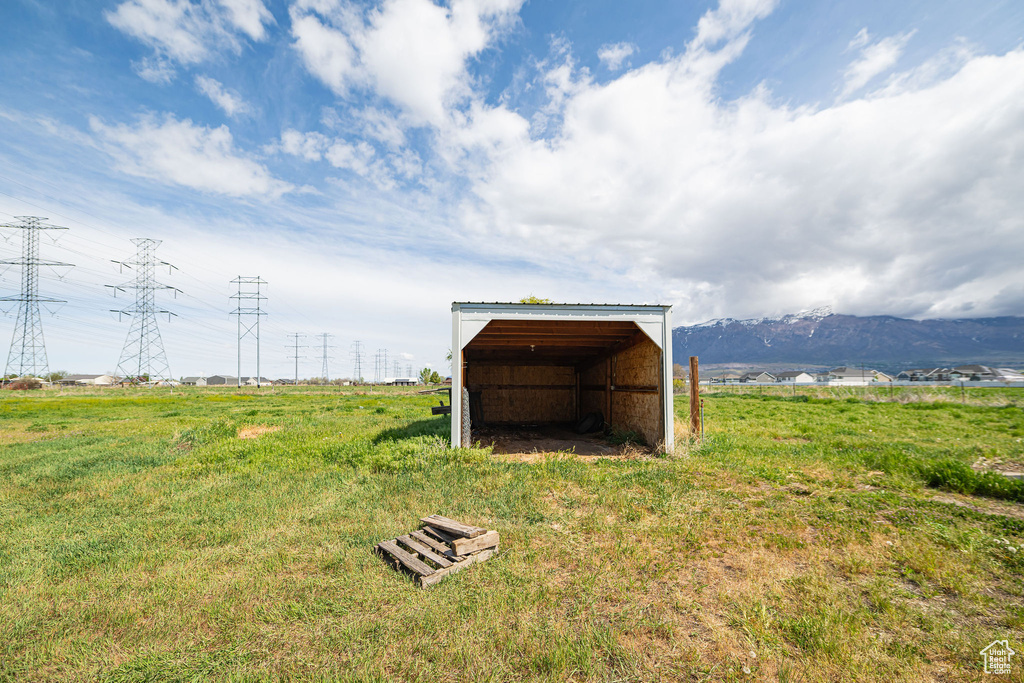 View of pole building featuring a lawn and a mountain view