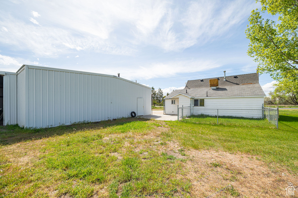 View of yard with an outdoor structure, a pole building, and fence
