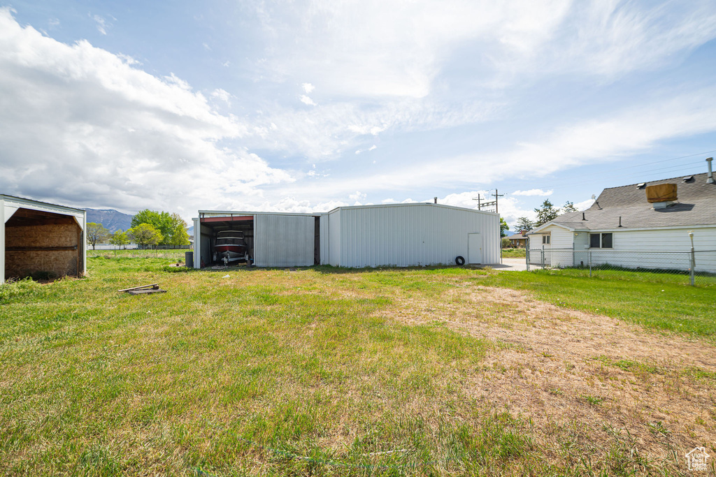 View of yard with fence and an outbuilding