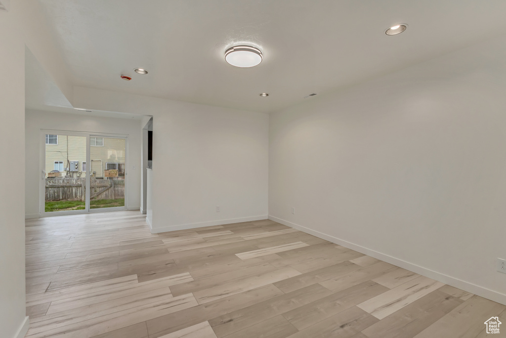 Empty room with baseboards, recessed lighting, and light wood-style flooring