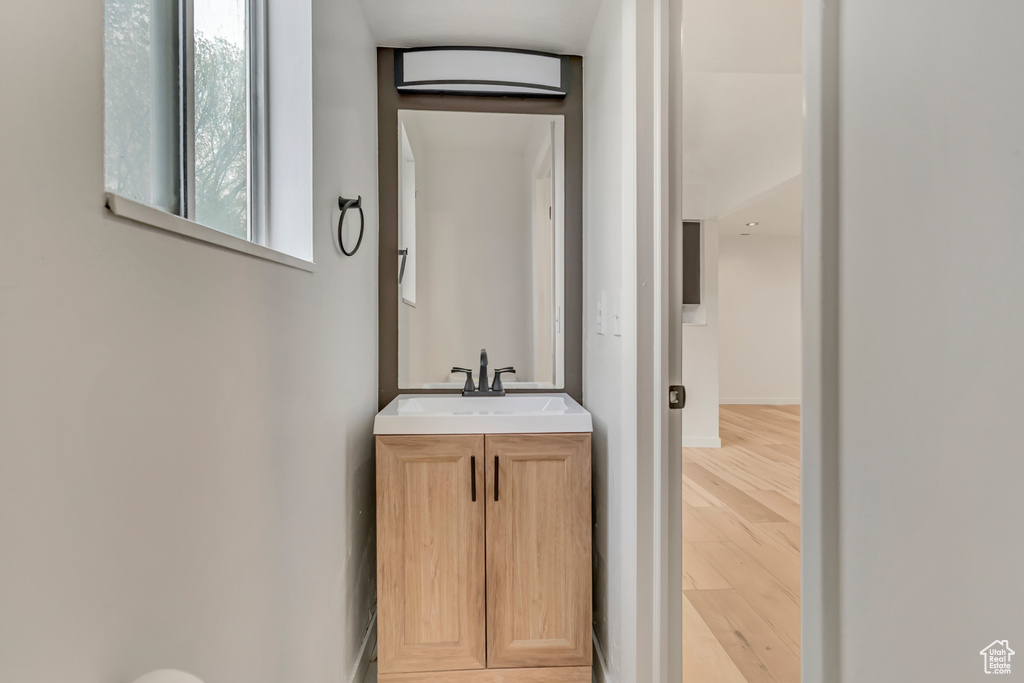 Bathroom with baseboards, wood finished floors, and vanity
