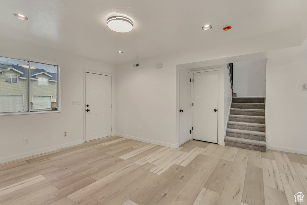 Interior space featuring baseboards, stairway, and light wood-style flooring