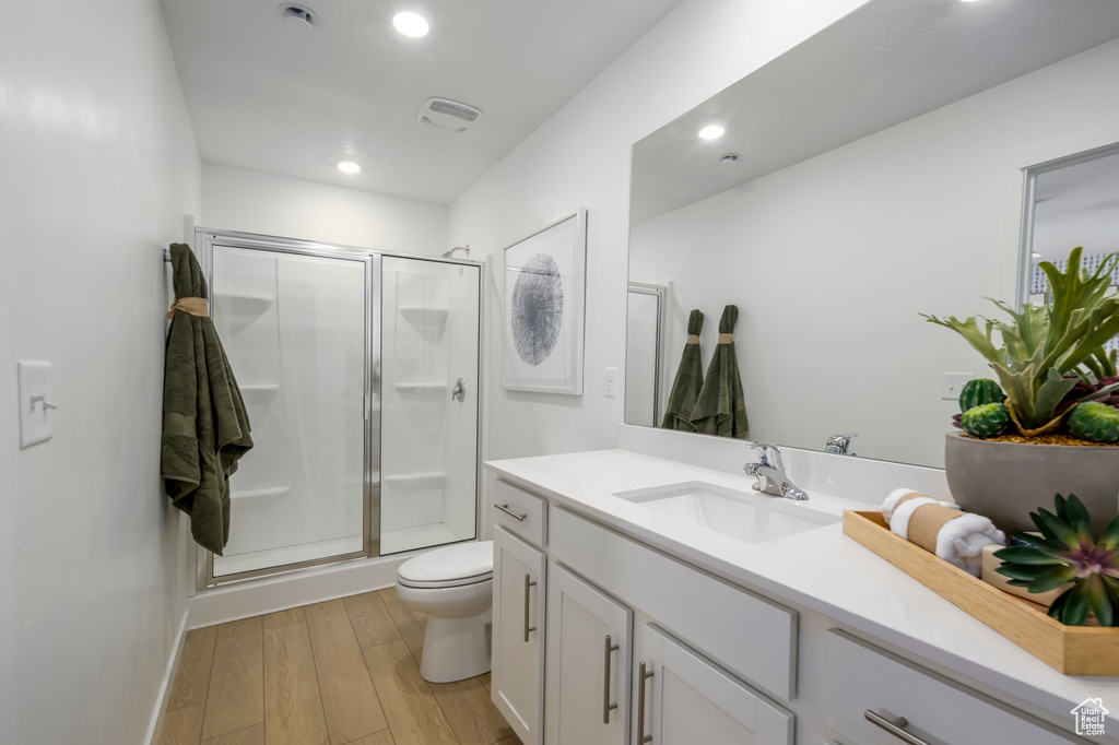 Full bath with vanity, a stall shower, recessed lighting, and wood finished floors