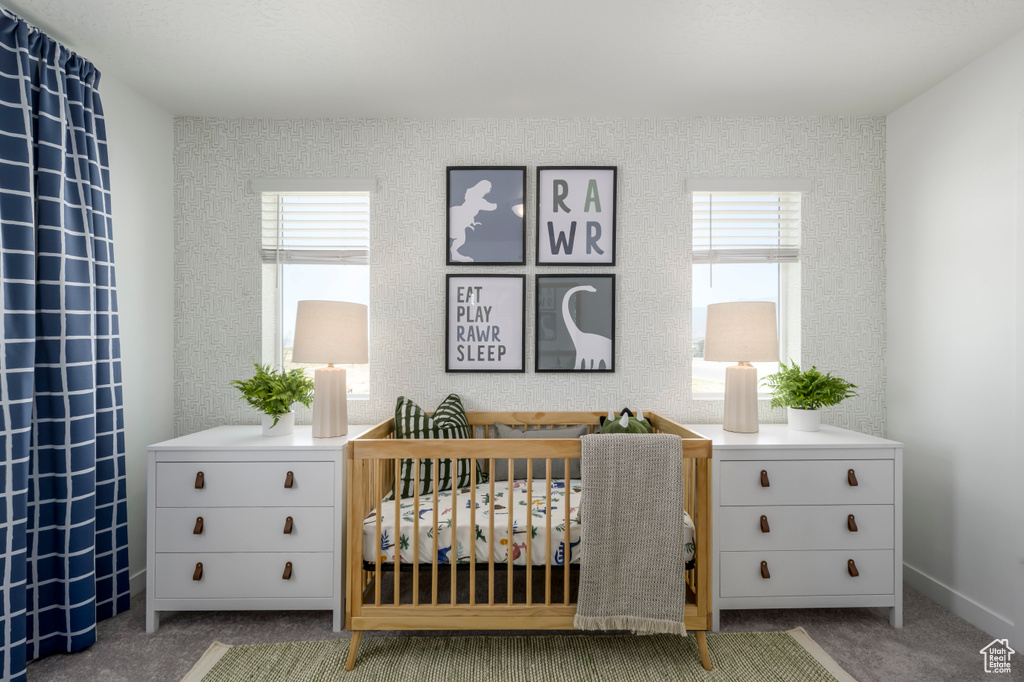 Bedroom with carpet floors, multiple windows, and a nursery area