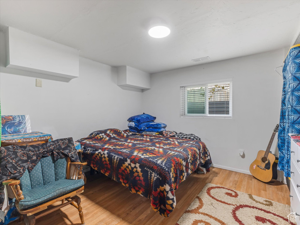 Bedroom with wood finished floors and visible vents