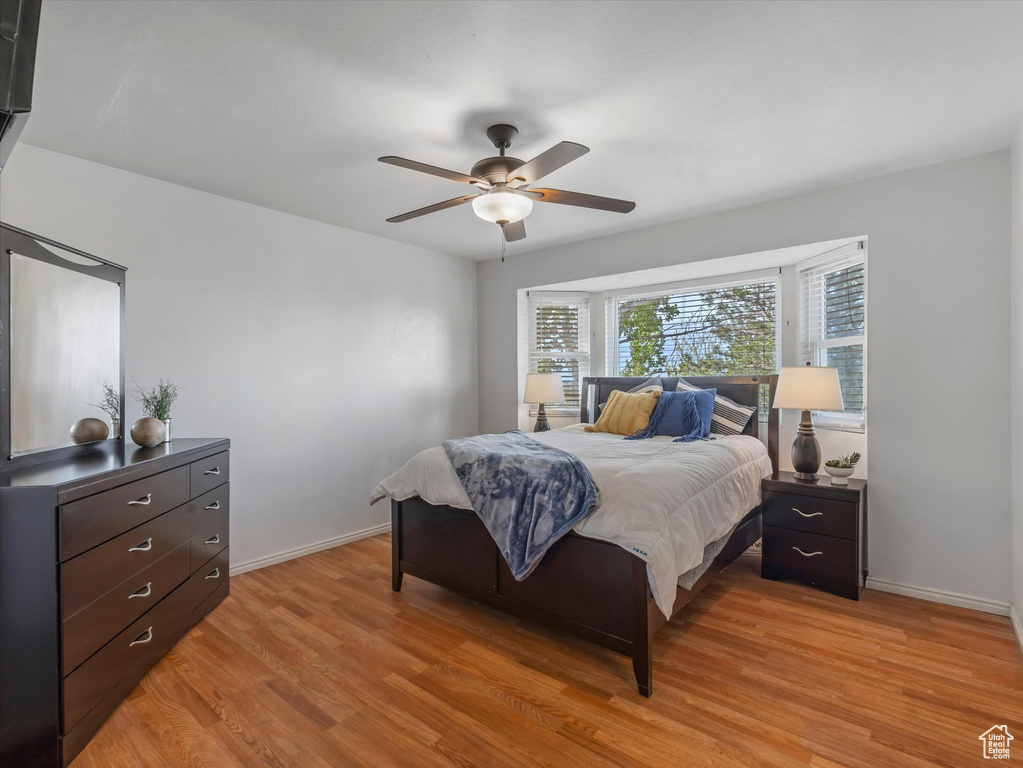 Bedroom featuring baseboards, ceiling fan, and light wood-type flooring