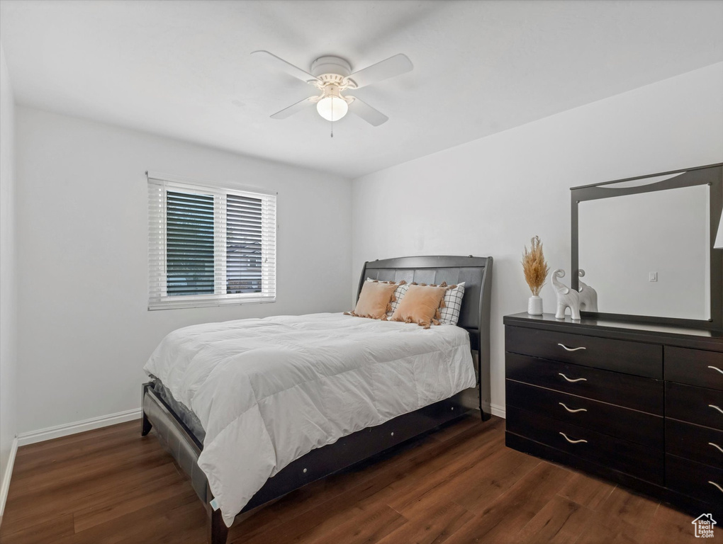 Bedroom with a ceiling fan, baseboards, and dark wood finished floors