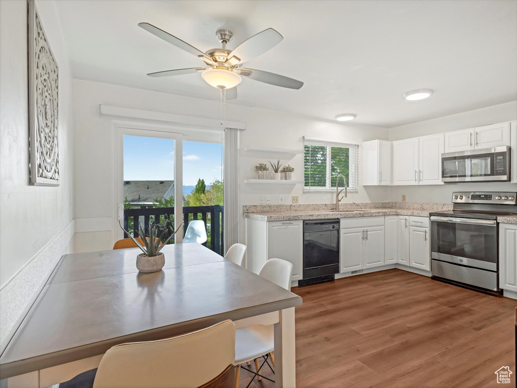Kitchen with open shelves, a ceiling fan, white cabinetry, a sink, and appliances with stainless steel finishes