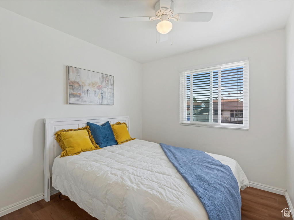 Bedroom with a ceiling fan, baseboards, and wood finished floors