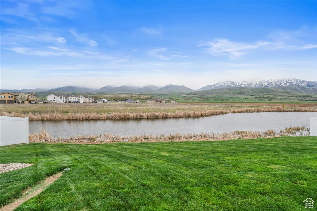 View of water feature featuring fence and a mountain view