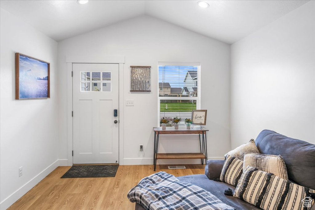Foyer entrance featuring visible vents, light wood-style floors, baseboards, recessed lighting, and vaulted ceiling