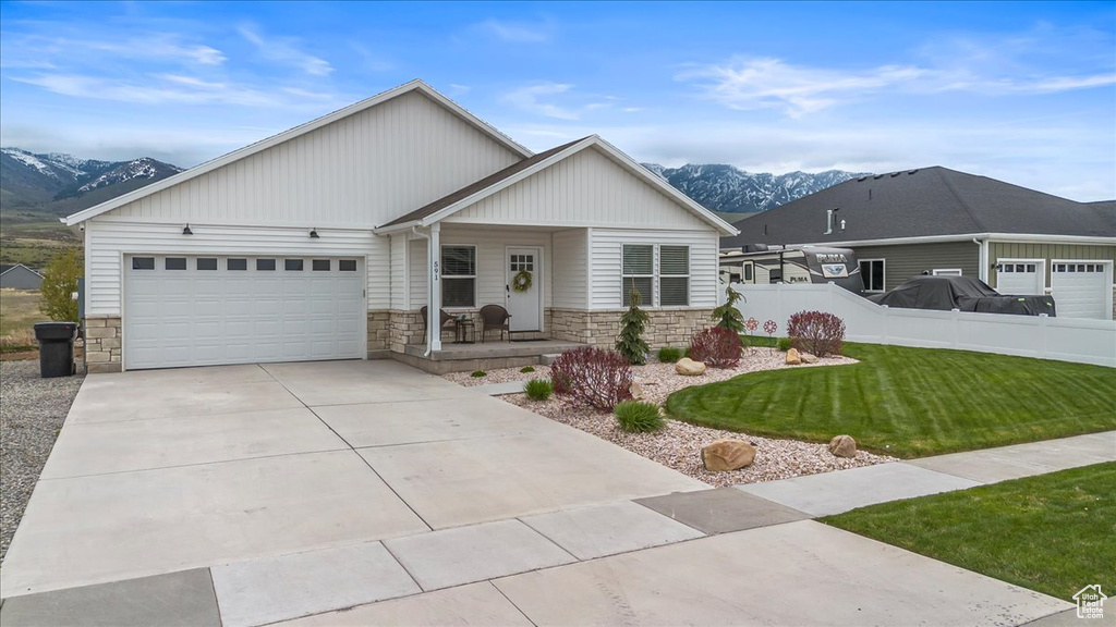 Single story home featuring a porch, a mountain view, and stone siding