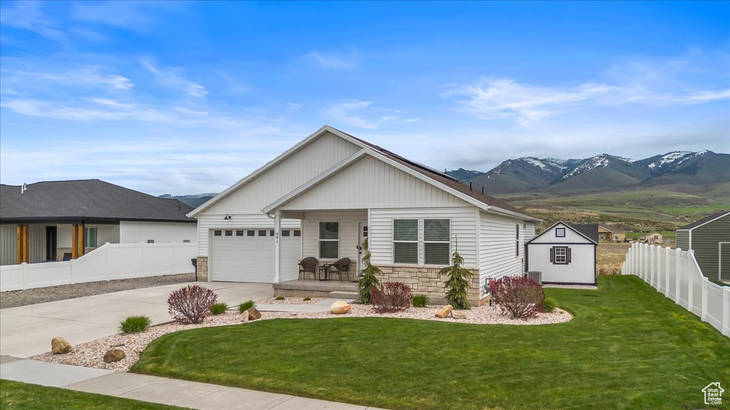 Ranch-style house with fence, driveway, and a front yard