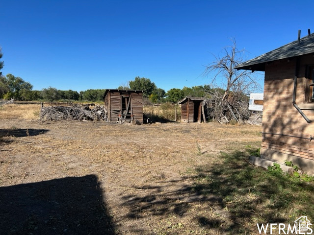 View of yard with an outbuilding and a storage shed
