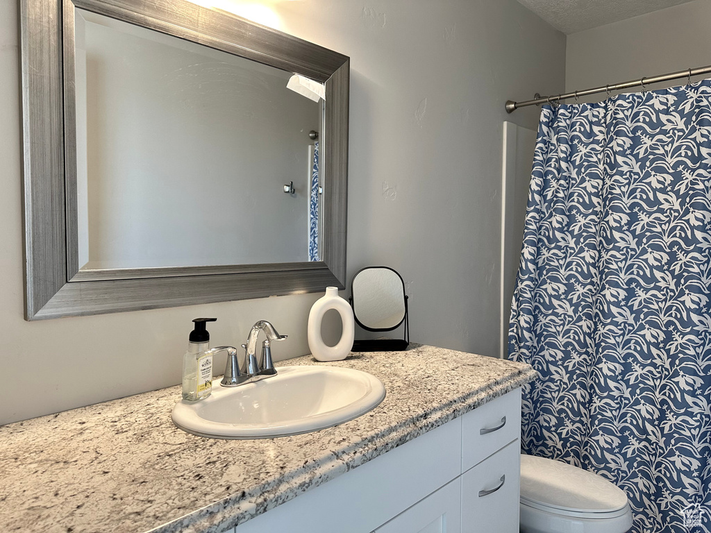 Full bath with vanity, toilet, and a shower with curtain