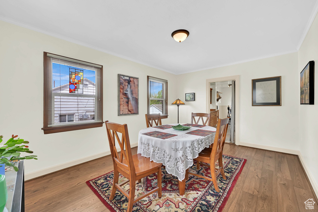 Dining space with baseboards, ornamental molding, and wood finished floors