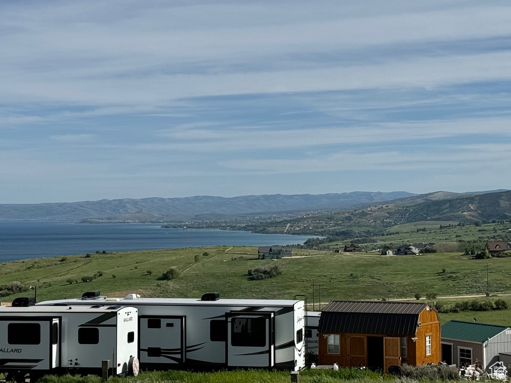 Property view of mountains featuring a water view and a rural view