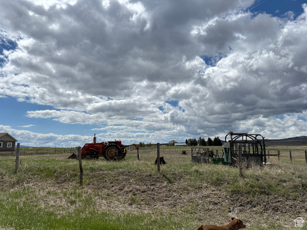View of yard with fence and a rural view