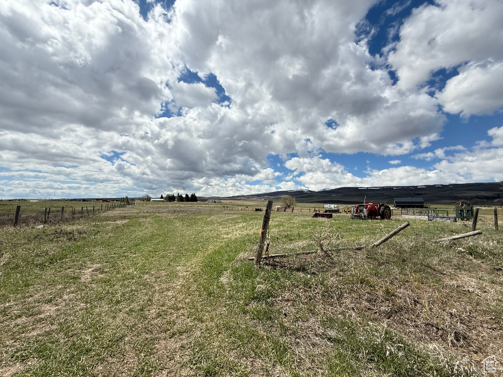 View of yard with fence and a rural view