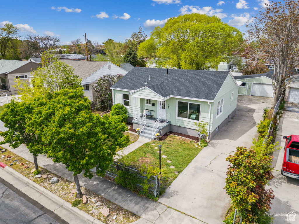 View of front of property with a detached garage, fence, a residential view, and roof with shingles
