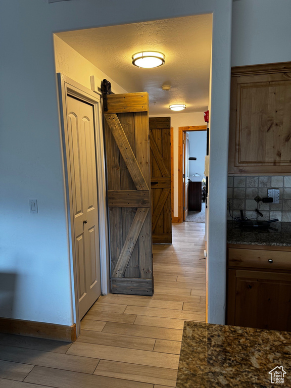 Hall with light wood finished floors and baseboards