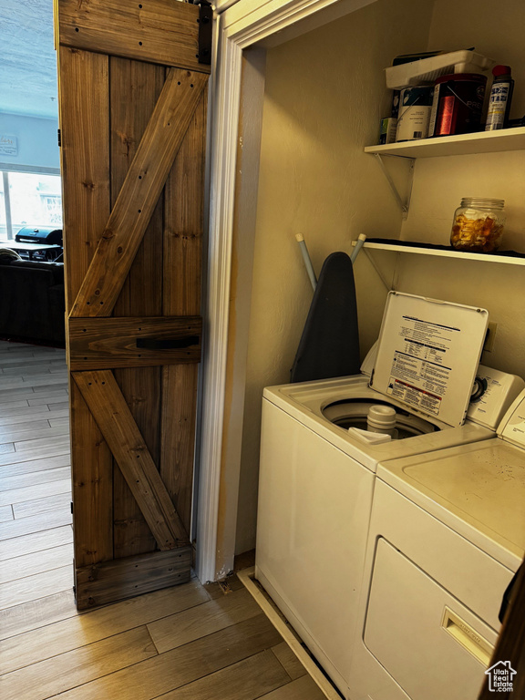 Laundry room with separate washer and dryer, laundry area, and light wood-style flooring