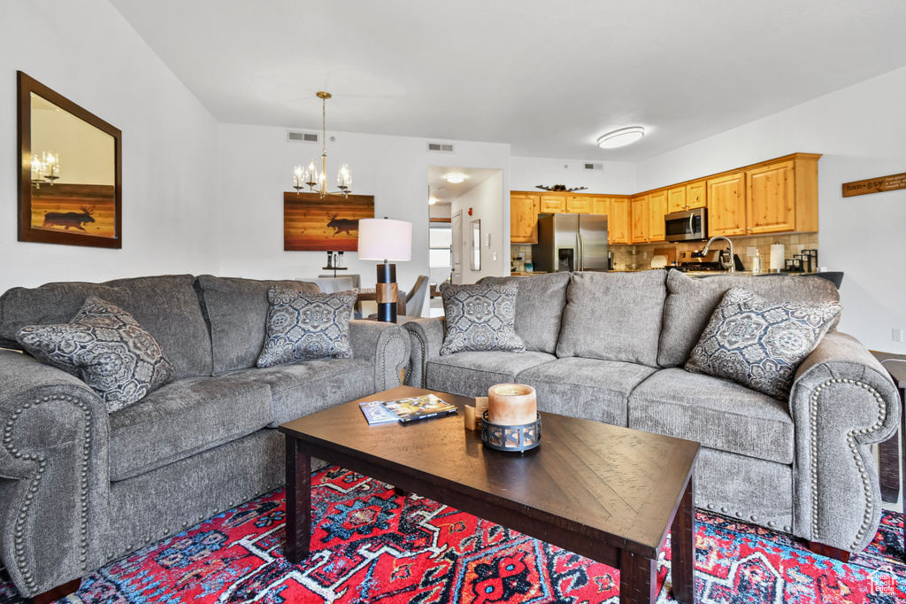 Living area with visible vents and an inviting chandelier
