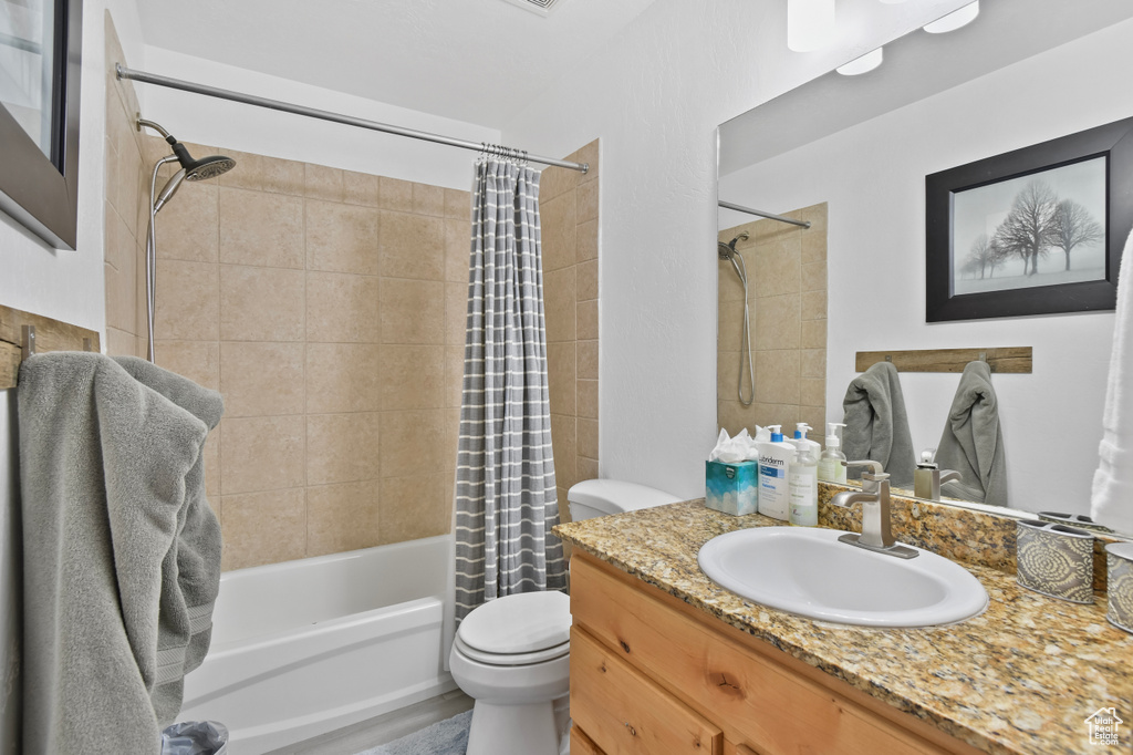 Full bathroom featuring vanity, toilet, and shower / tub combo with curtain