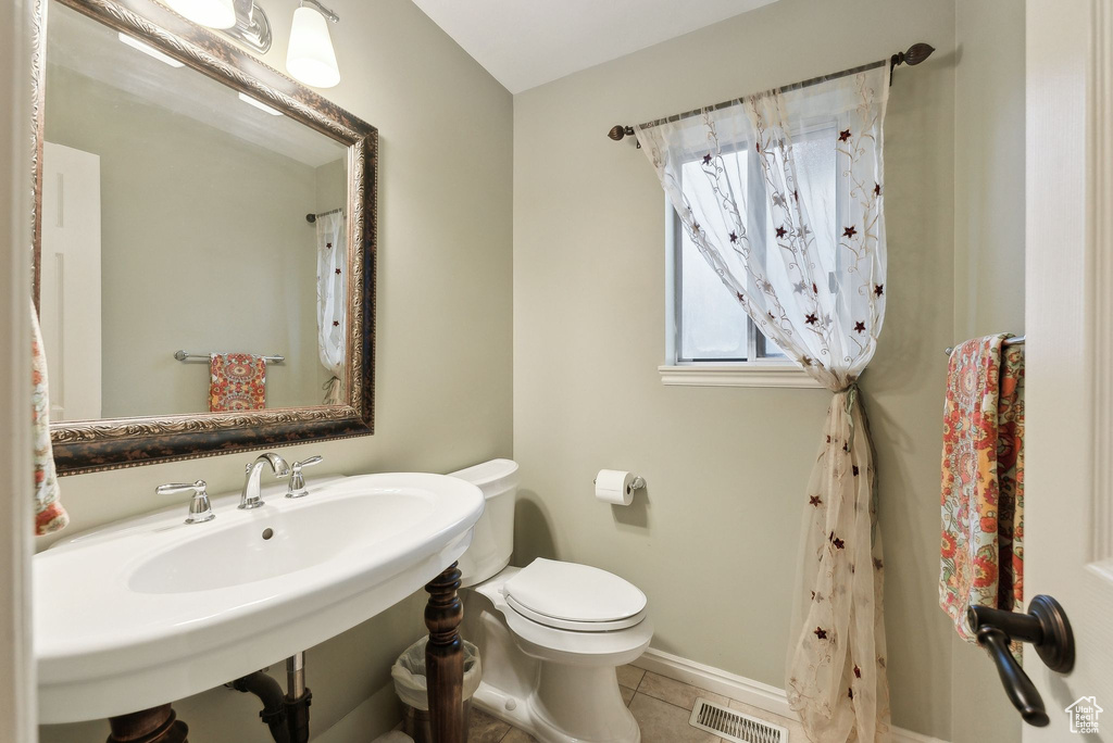 Bathroom featuring toilet, baseboards, visible vents, and tile patterned flooring