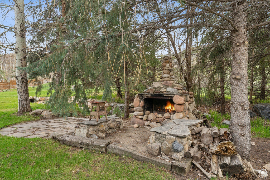 View of yard with an outdoor stone fireplace
