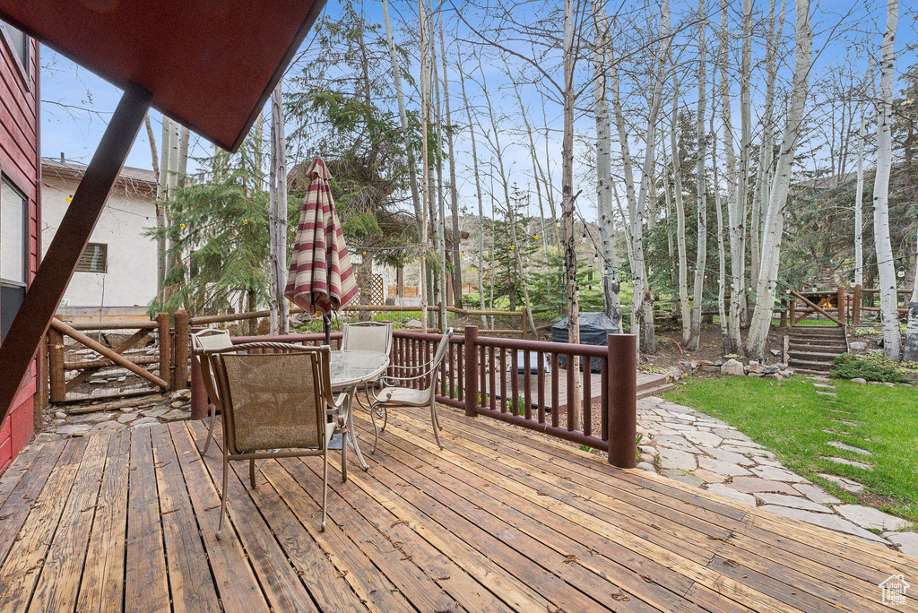 Wooden deck featuring a yard and outdoor dining space