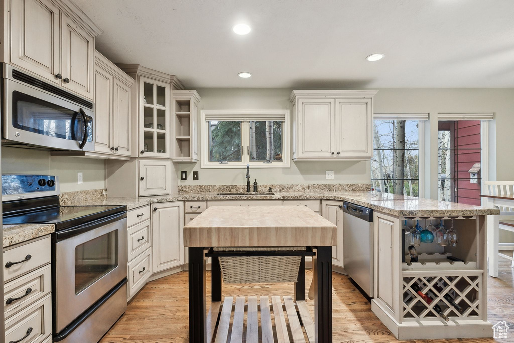 Kitchen with a sink, stainless steel appliances, a peninsula, and a wealth of natural light