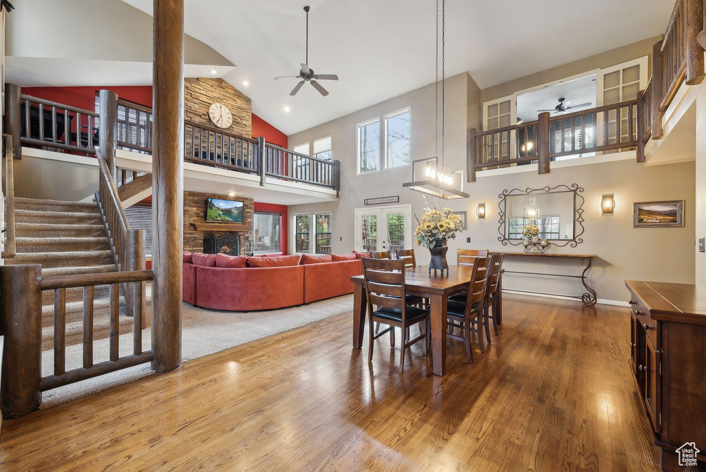 Dining room featuring baseboards, a ceiling fan, high vaulted ceiling, and wood finished floors