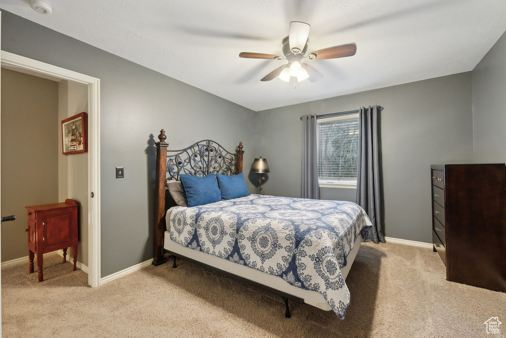 Bedroom featuring light colored carpet, a ceiling fan, and baseboards