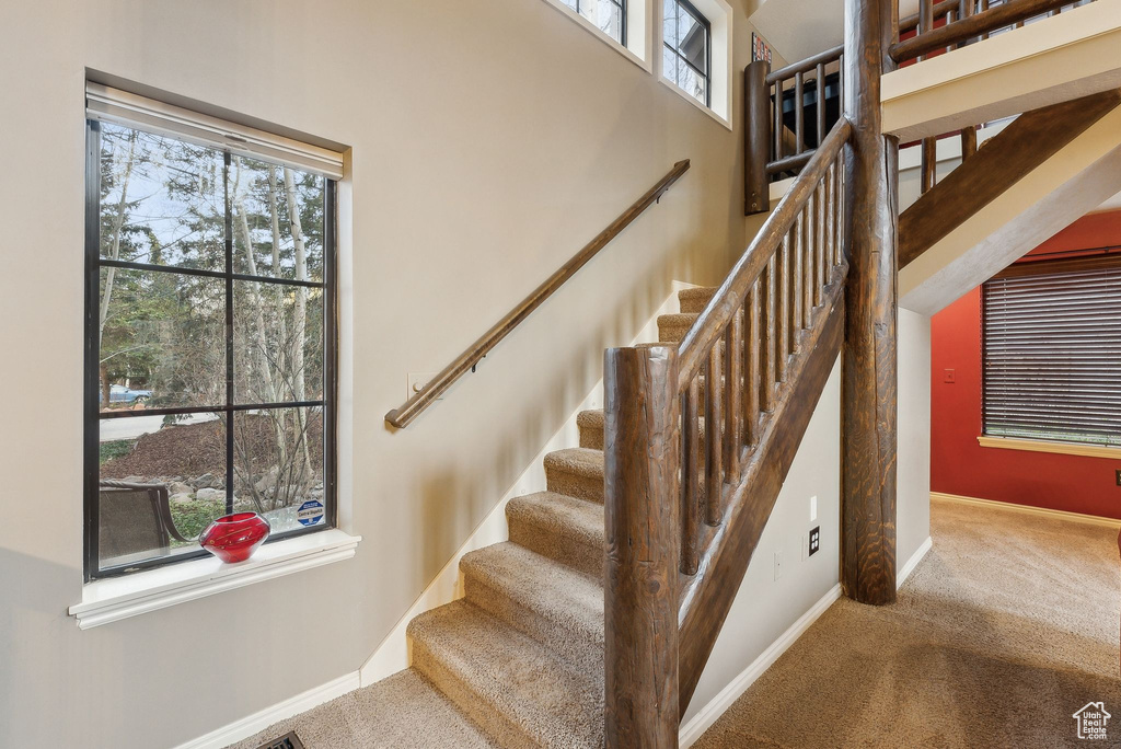 Stairs with baseboards, carpet, and a healthy amount of sunlight