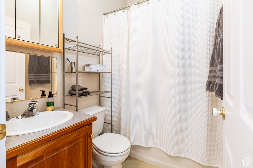 Full bath with vanity, shower / bathtub combination with curtain, and toilet