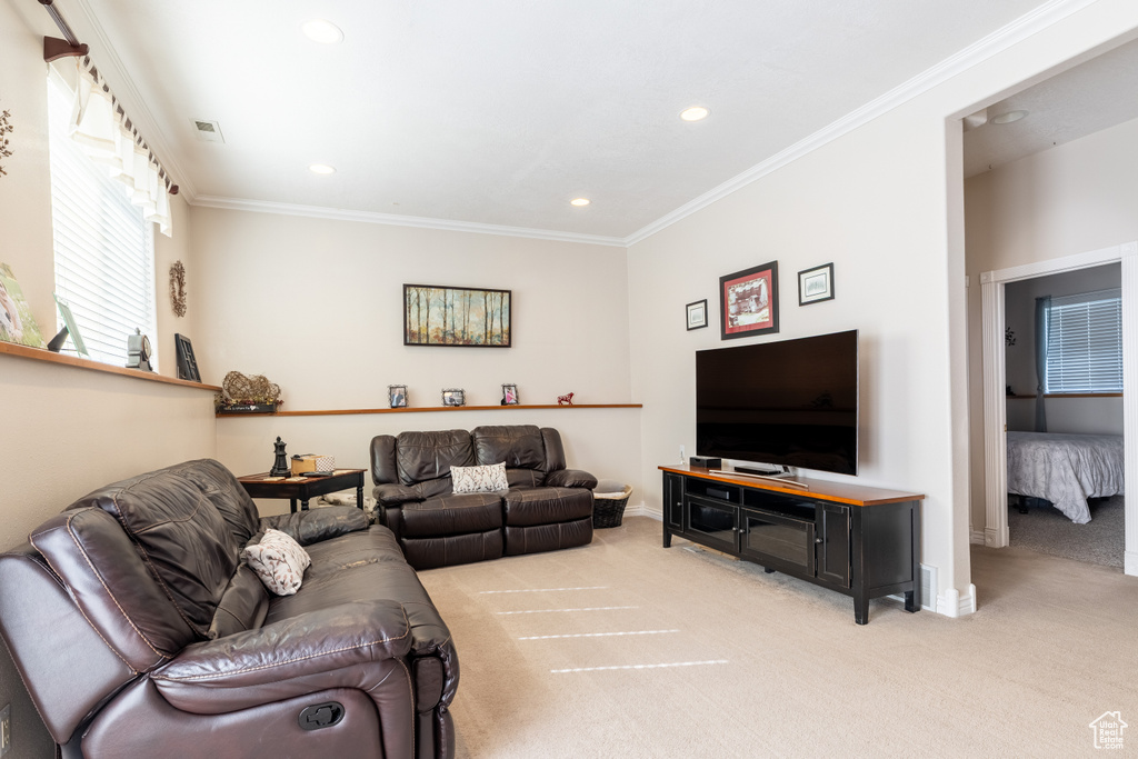 Living room featuring baseboards, ornamental molding, recessed lighting, and light carpet