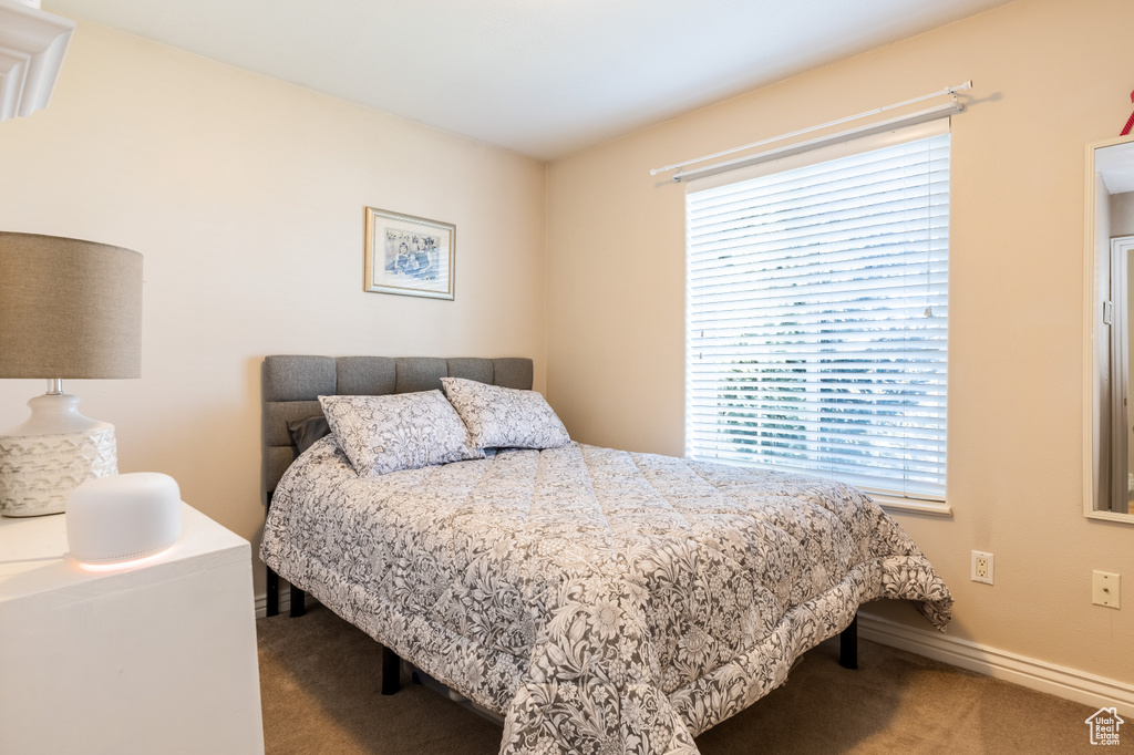 Bedroom featuring baseboards and carpet