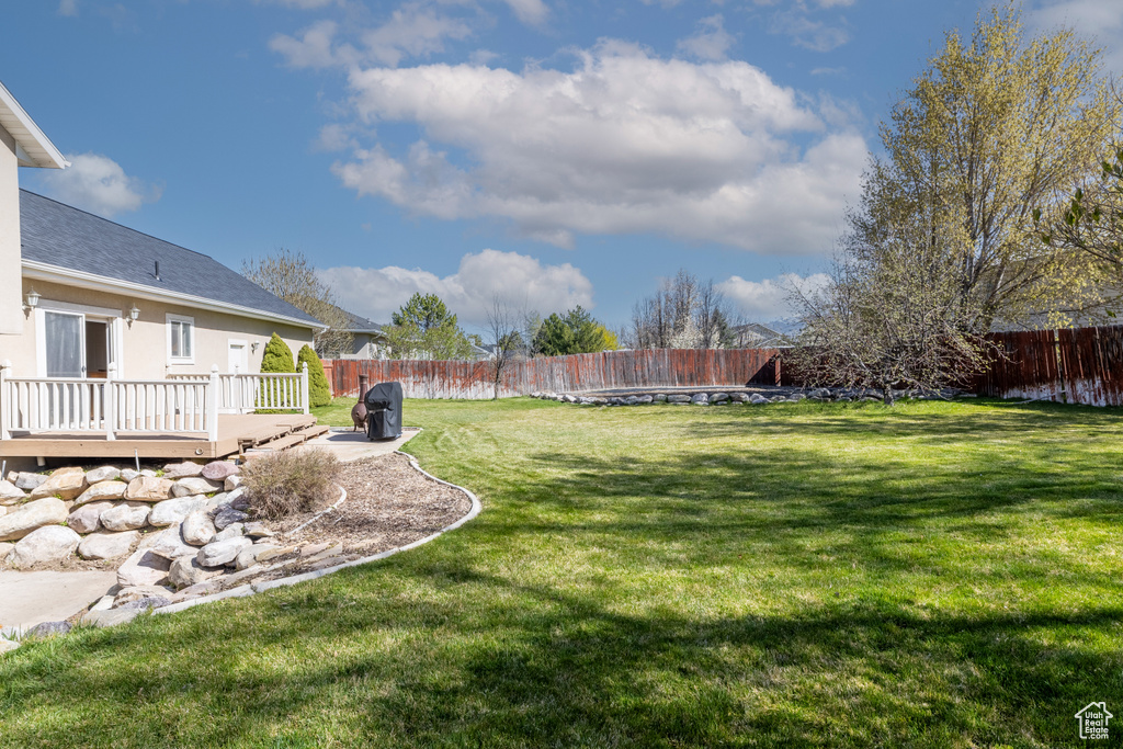 View of yard with a fenced backyard and a deck