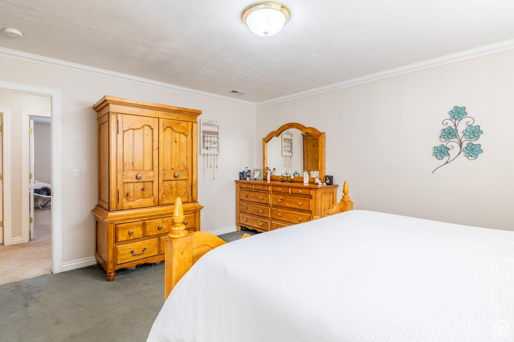 Bedroom featuring baseboards, ornamental molding, and carpet