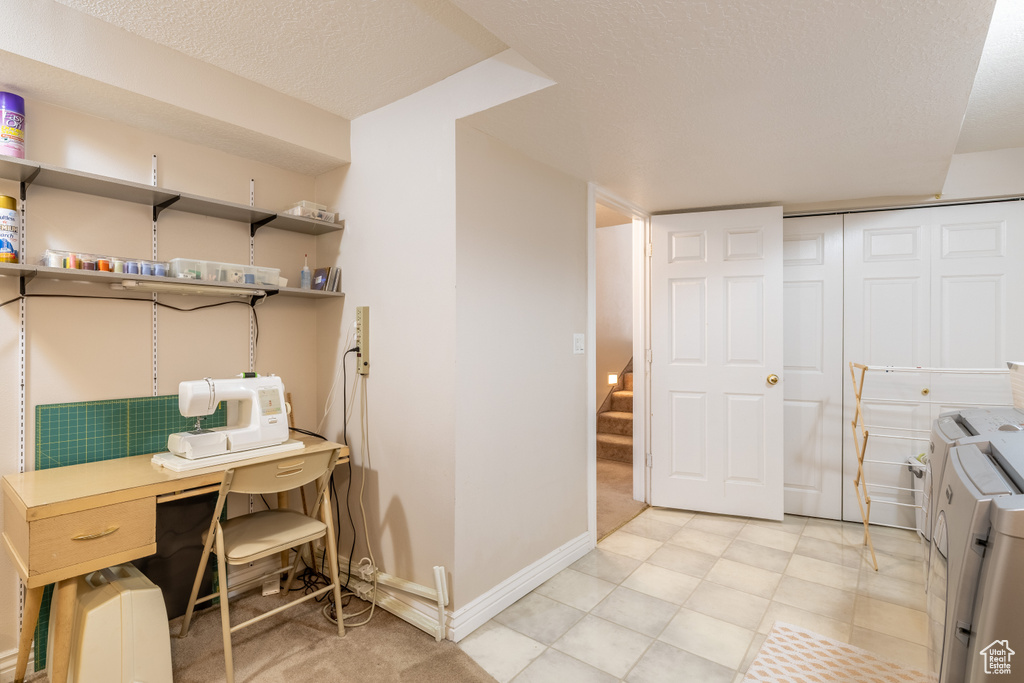 Interior space with baseboards, laundry area, a textured ceiling, and washer and clothes dryer