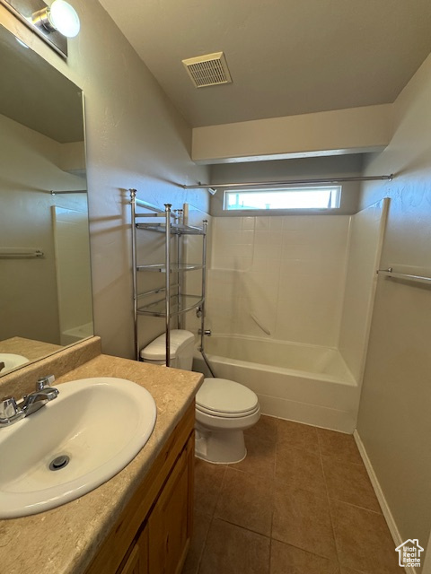 Full bath with visible vents, vanity, shower / bathtub combination, toilet, and tile patterned floors