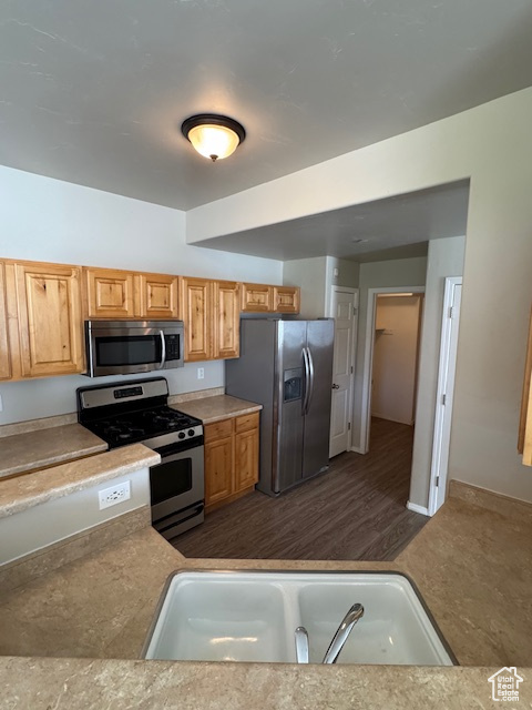Kitchen with a sink, appliances with stainless steel finishes, and light countertops
