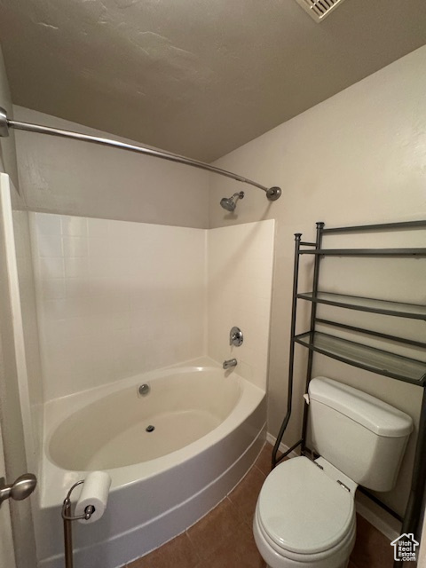 Full bath with toilet, tile patterned floors, baseboards,  shower combination, and visible vents