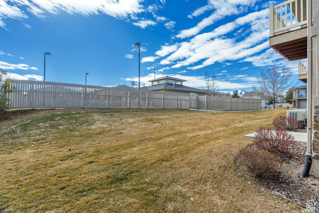 View of yard with fence and central air condition unit
