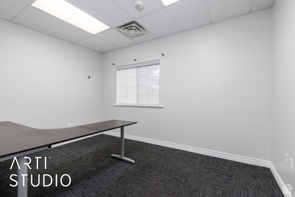 Unfurnished office with carpet flooring, baseboards, visible vents, and a drop ceiling