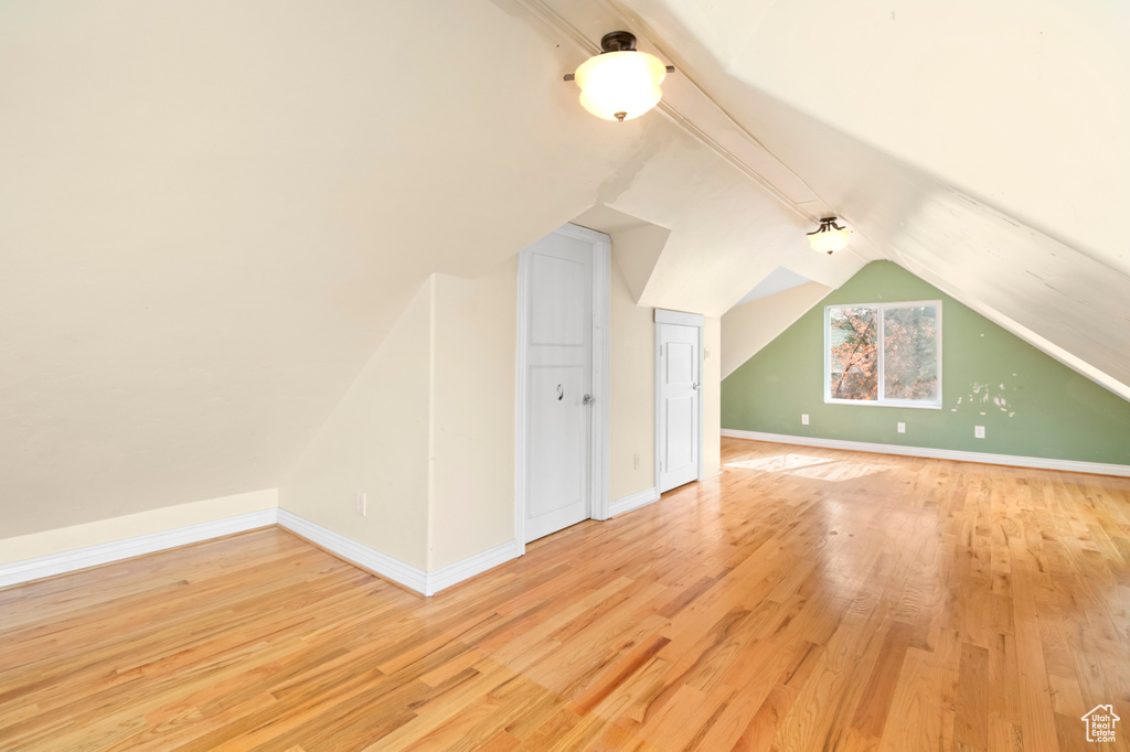Bonus room with baseboards, vaulted ceiling, and wood finished floors